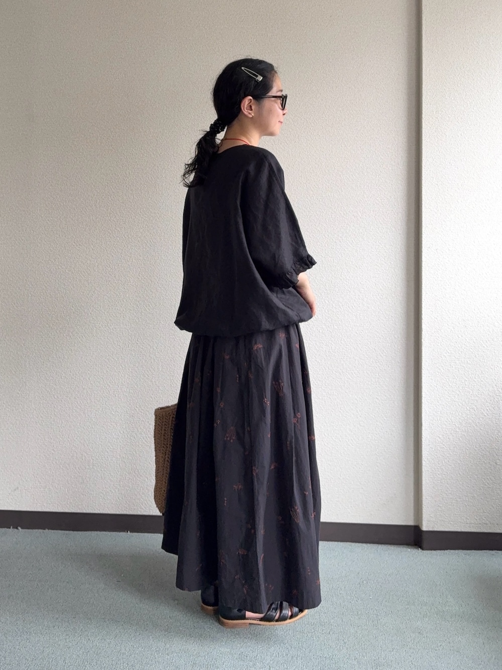 ブラック系のスカート、ベージュ系のトートバッグ、ブラック系のサンダルを着用したレディースの夏コーディネートの4枚目の写真