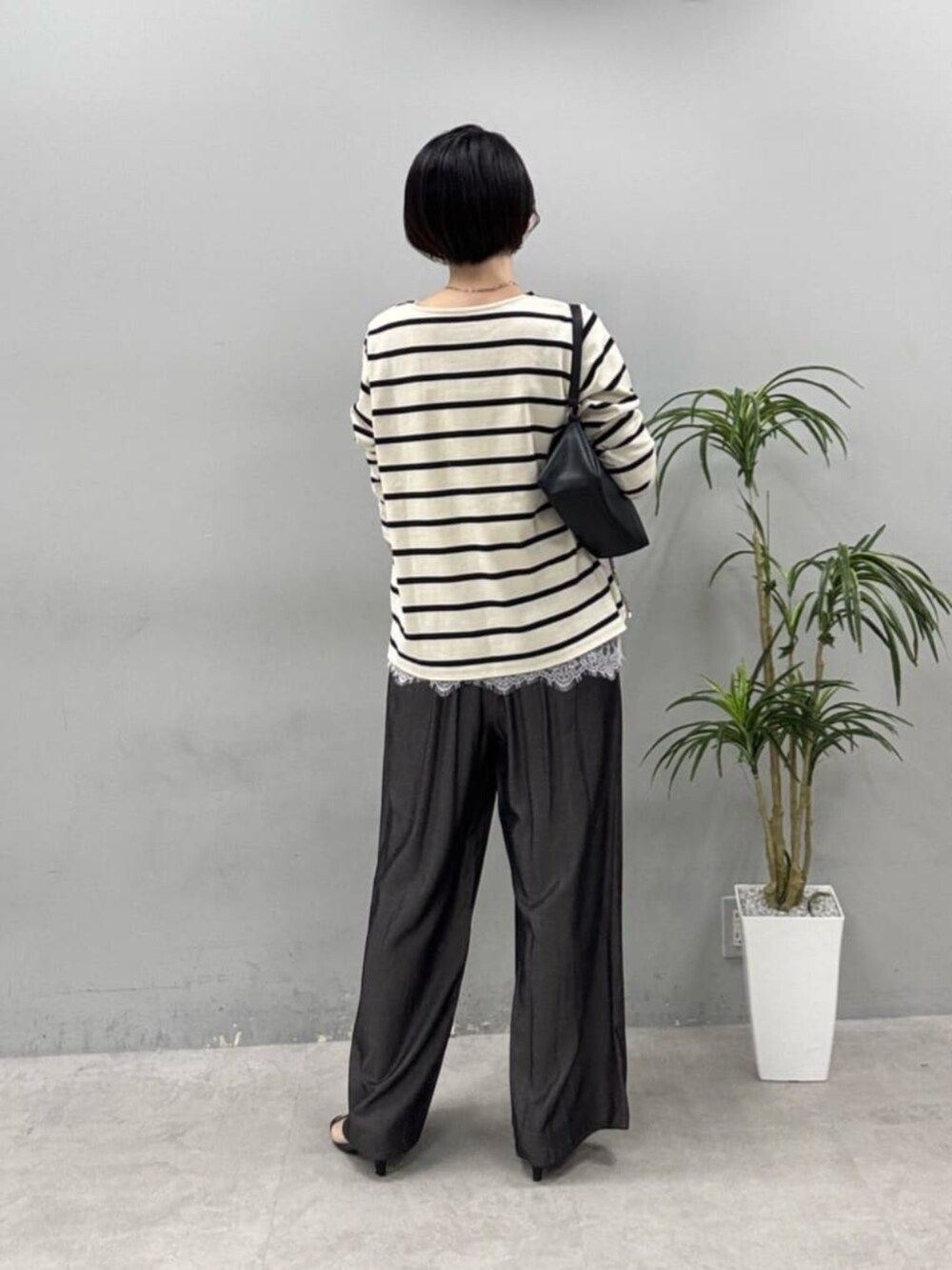 ブラック系のショルダーバッグ、ホワイト系のTシャツ/カットソーを着用したレディースの春コーディネートの2枚目の写真