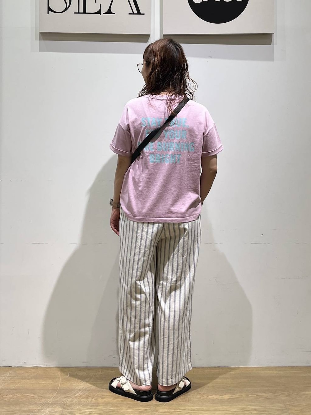 パープル系のTシャツ/カットソー、ホワイト系のその他パンツ、その他のショルダーバッグを着用したレディースの春コーディネートの3枚目の写真