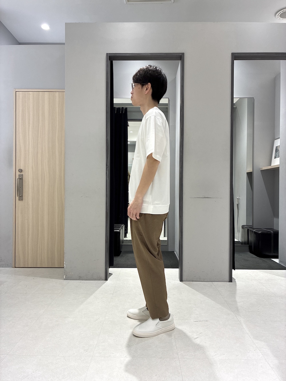グリーン系のバックパック/リュック、ホワイト系のTシャツ/カットソー、ブラック系のニット/セーターを着用したメンズの春コーディネートの6枚目の写真