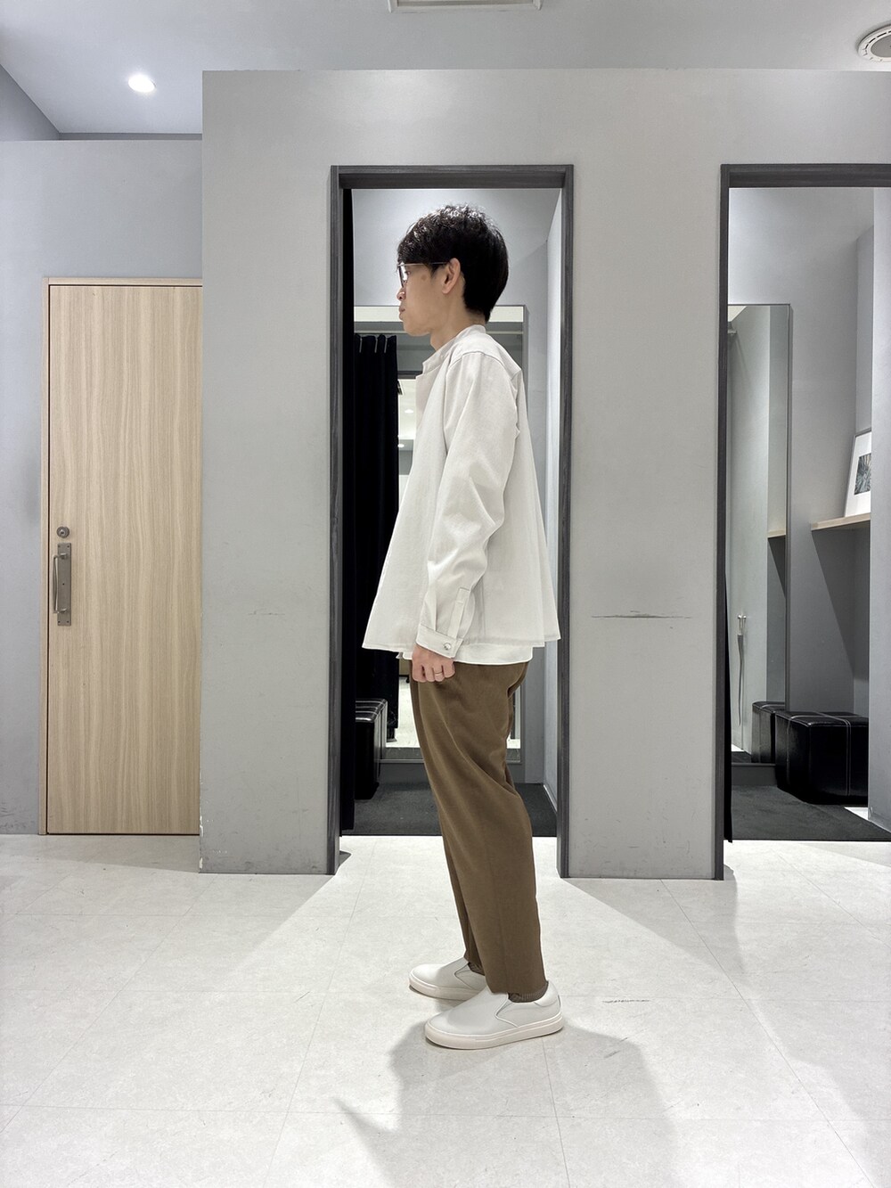 グリーン系のバックパック/リュック、ホワイト系のTシャツ/カットソー、ブラック系のニット/セーターを着用したメンズの春コーディネートの2枚目の写真