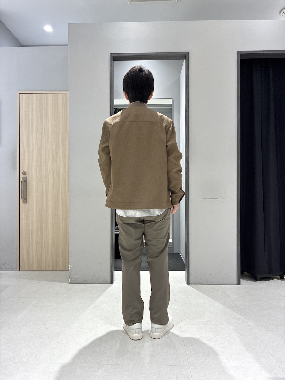 グレー系のシャツ/ブラウス、グレー系のバックパック/リュック、ホワイト系のポロシャツを着用したメンズの春コーディネートの3枚目の写真