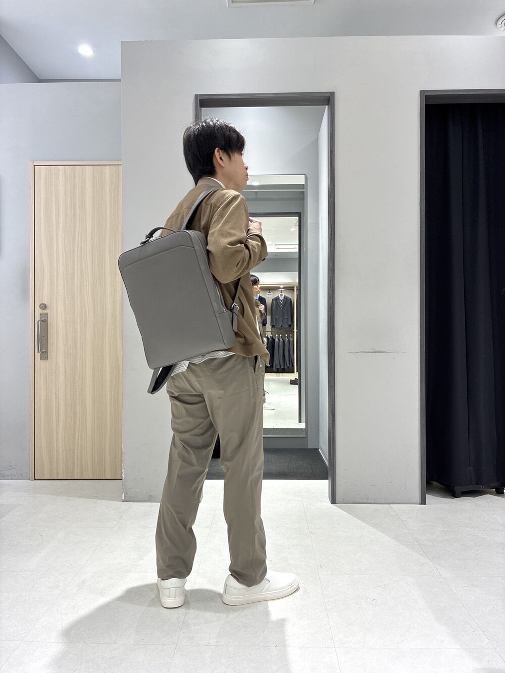 グレー系のシャツ/ブラウス、グレー系のバックパック/リュック、ホワイト系のポロシャツを着用したメンズの春コーディネートの10枚目の写真