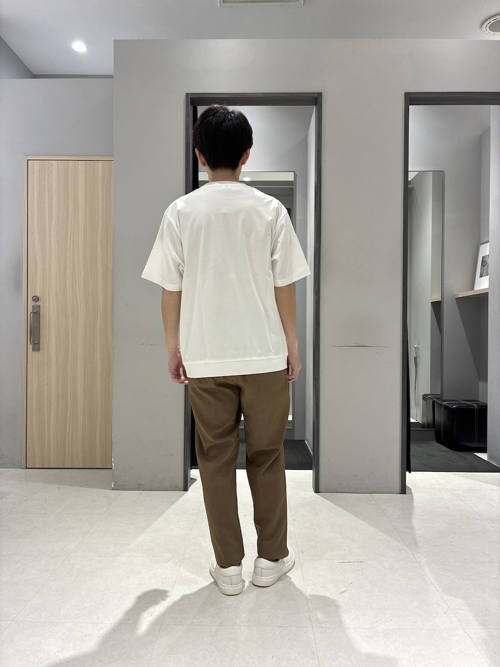 グリーン系のバックパック/リュック、ホワイト系のTシャツ/カットソー、ブラック系のニット/セーターを着用したメンズの春コーディネートの7枚目の写真