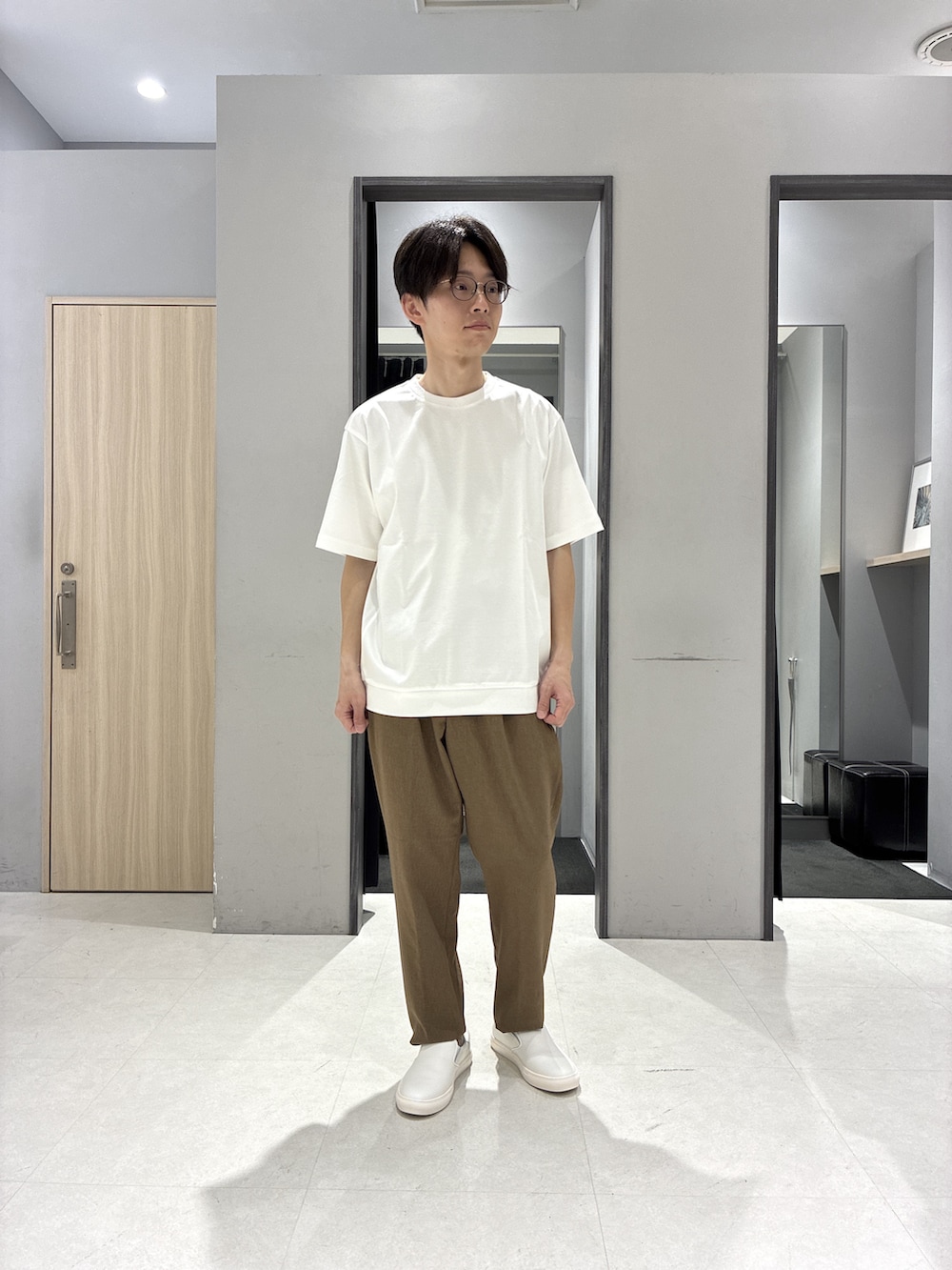 グリーン系のバックパック/リュック、ホワイト系のTシャツ/カットソー、ブラック系のニット/セーターを着用したメンズの春コーディネートの5枚目の写真