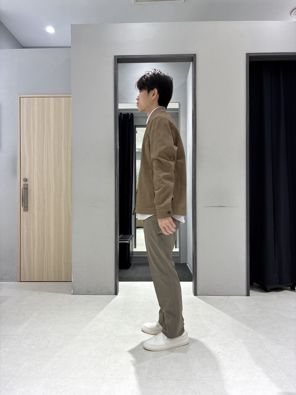 グレー系のシャツ/ブラウス、グレー系のバックパック/リュック、ホワイト系のポロシャツを着用したメンズの春コーディネートの2枚目の写真