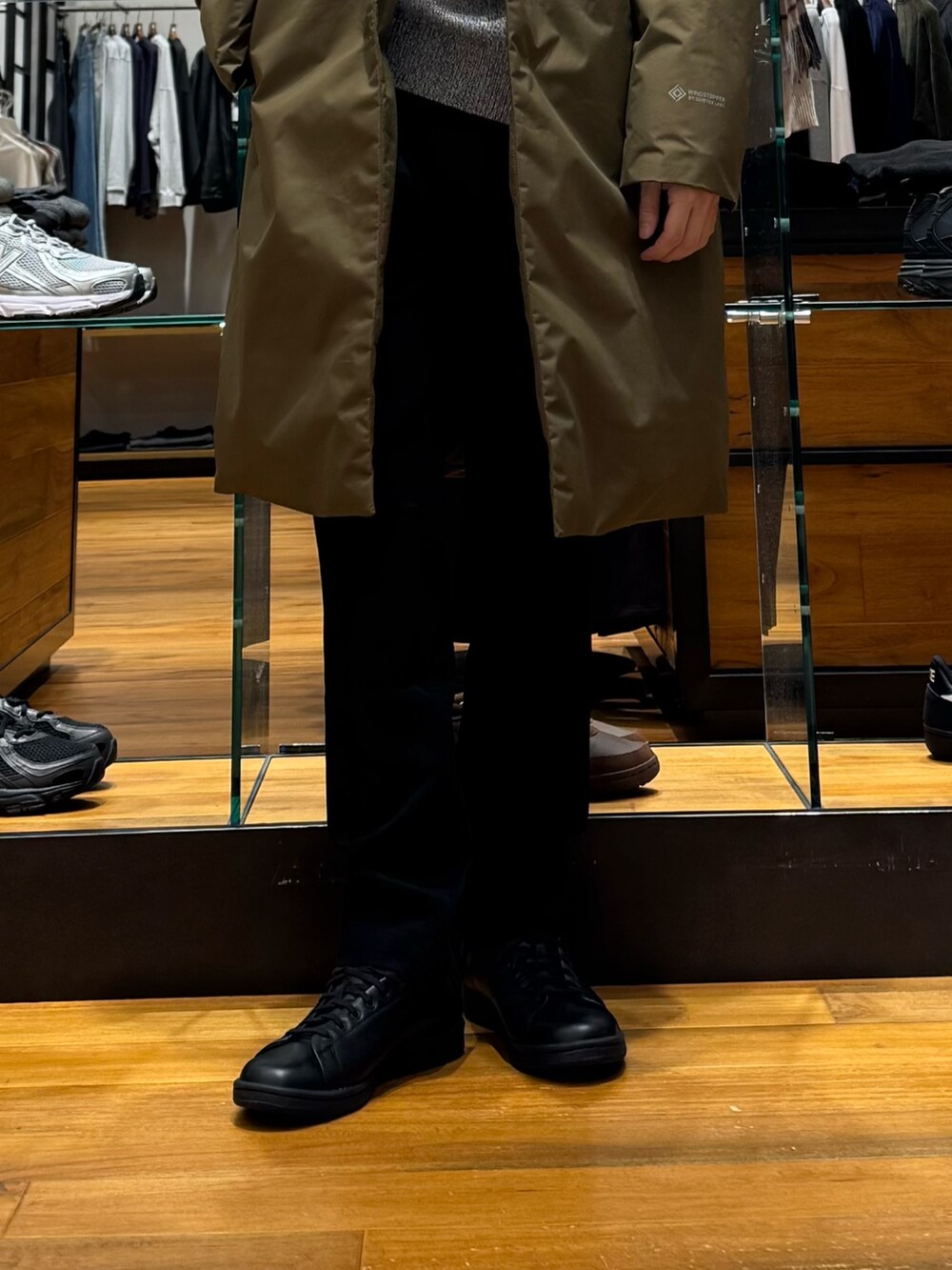 ブラウン系のダウンジャケット/コート、ブラック系のその他パンツ、グレー系のニット/セーターを着用したメンズの冬コーディネートの4枚目の写真