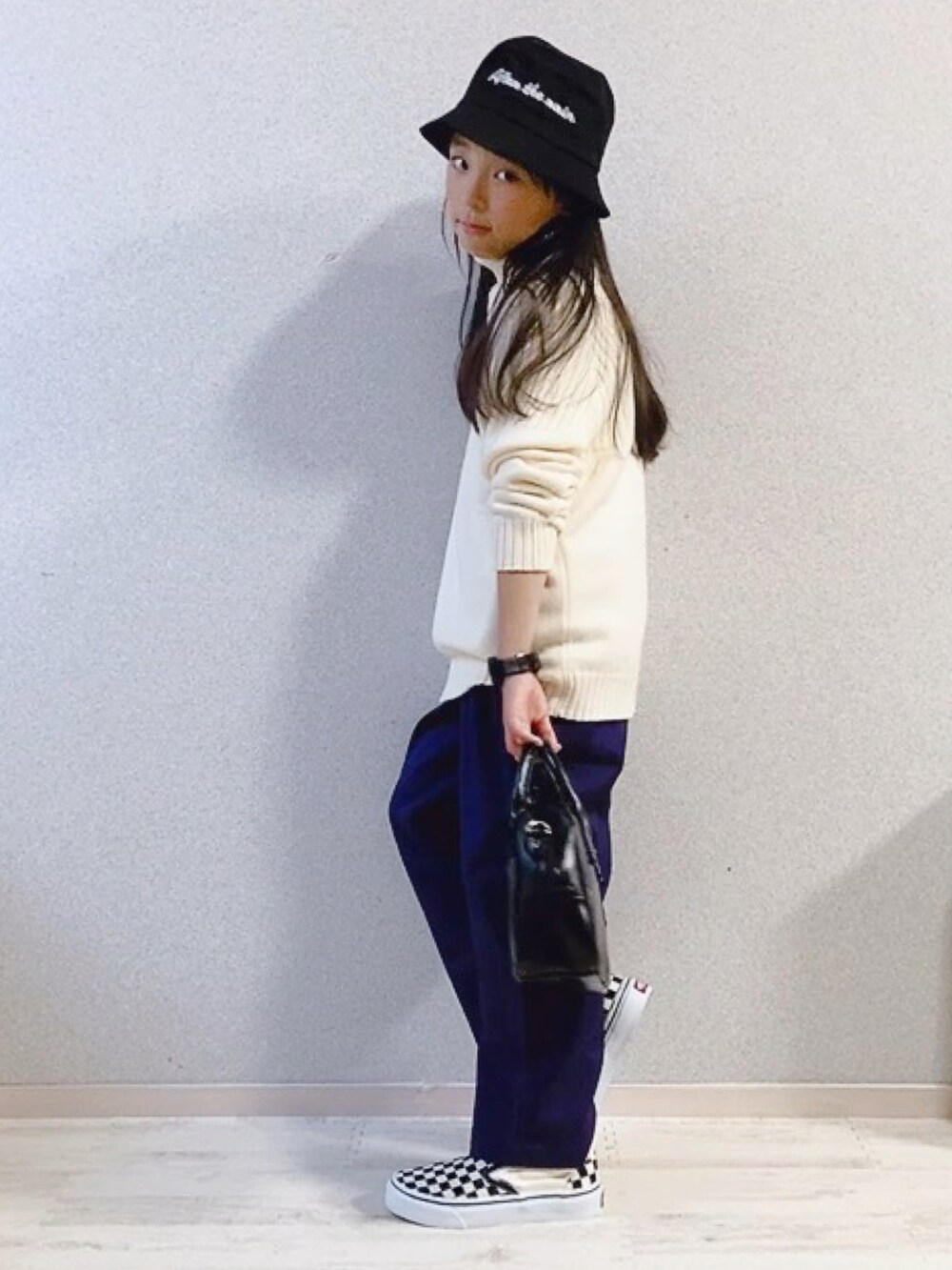 ホワイト系のニット/セーター、パープル系のその他パンツ、ブラック系のショルダーバッグを着用したキッズの冬コーディネートの2枚目の写真