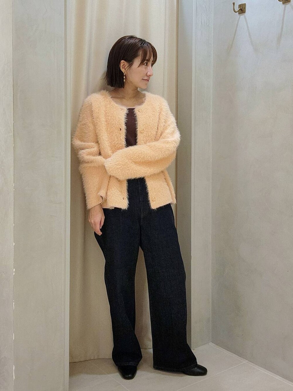 ブラック系のブーツ、ブルー系のデニムパンツ、ピンク系のニット/セーターを着用したレディースの秋コーディネートの3枚目の写真