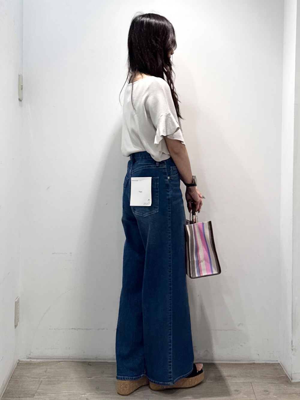ブルー系のデニムパンツ、ブラウン系のサンダル、ブラウン系のトートバッグを着用したレディースの春コーディネートの9枚目の写真