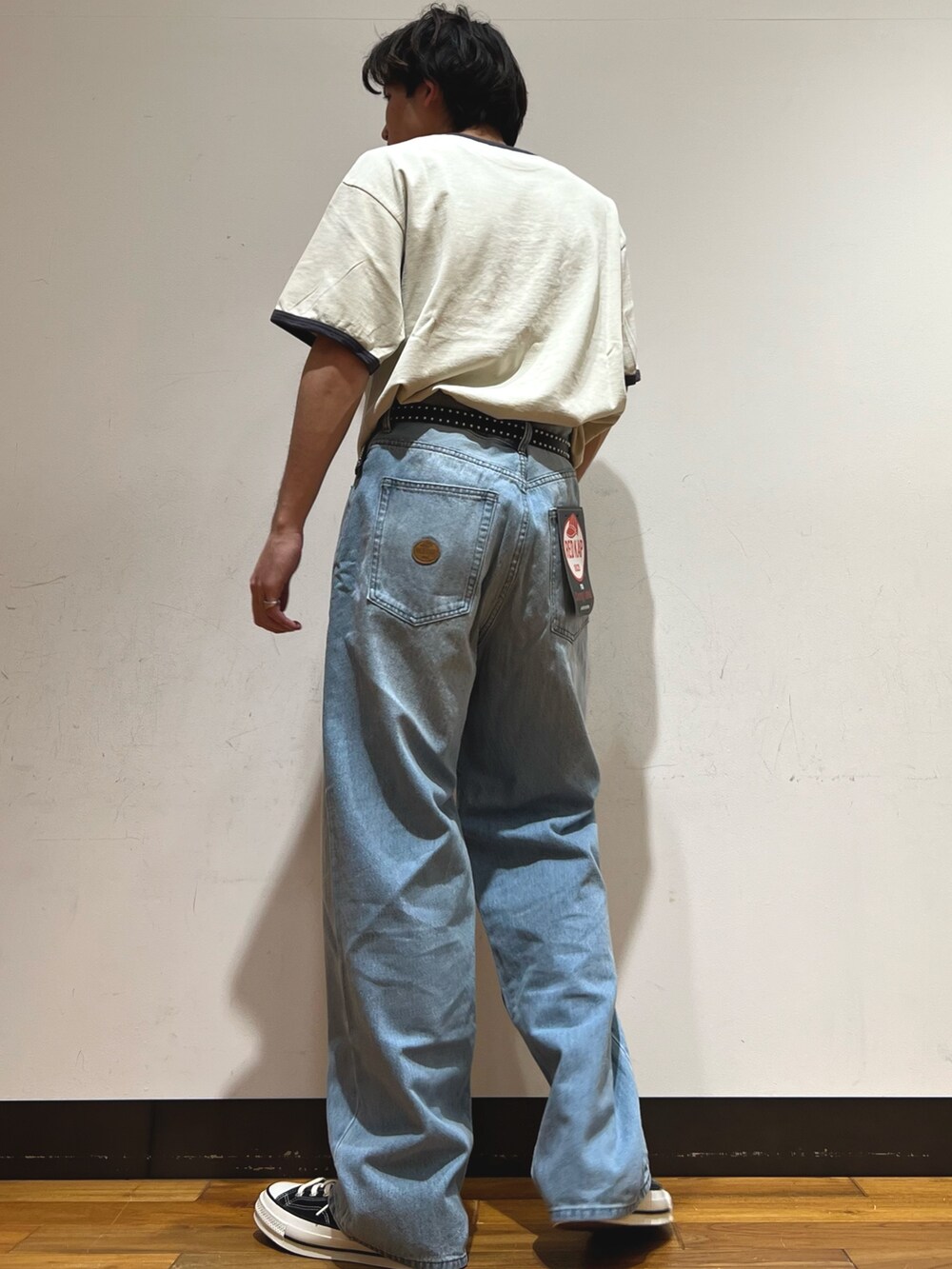 ブルー系のデニムパンツ、ブラック系のスニーカー、ベージュ系のTシャツ/カットソーを着用したメンズの春コーディネートの3枚目の写真