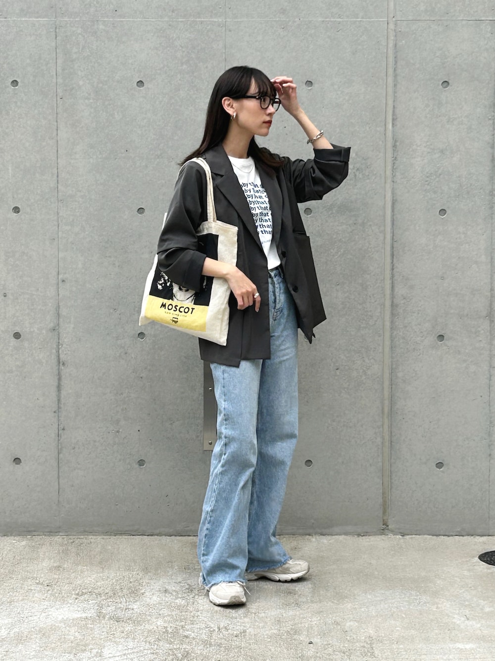 グレー系のテーラードジャケット、ホワイト系のTシャツ/カットソー、ブルー系のデニムパンツを着用したレディースの春コーディネートの2枚目の写真