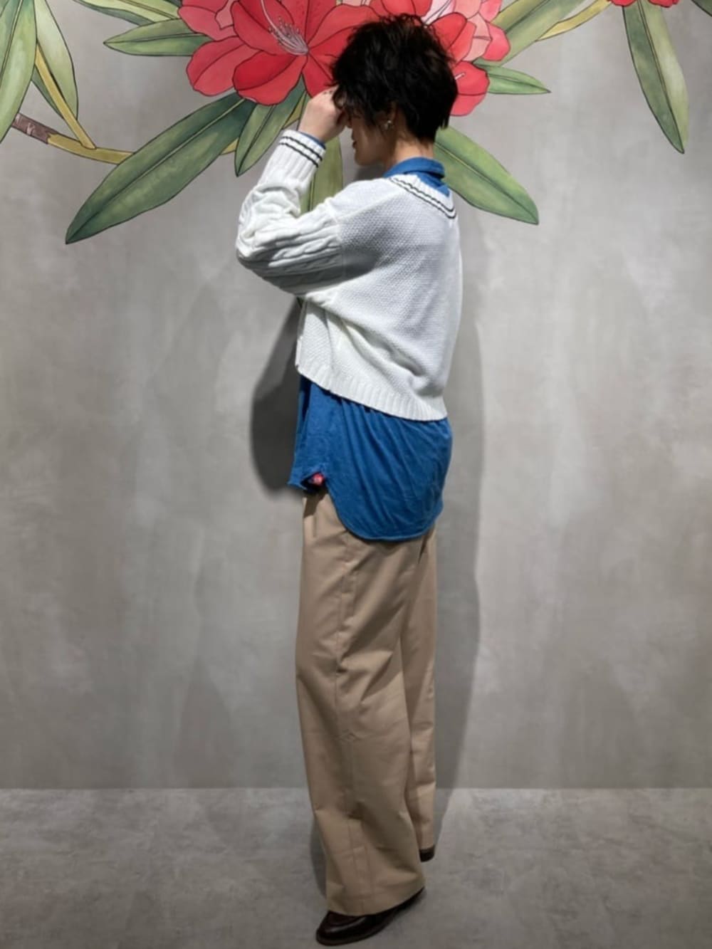 ベージュ系のチノパンツ、ブルー系のシャツ/ブラウス、ホワイト系のニット/セーターを着用したレディースの春コーディネートの5枚目の写真