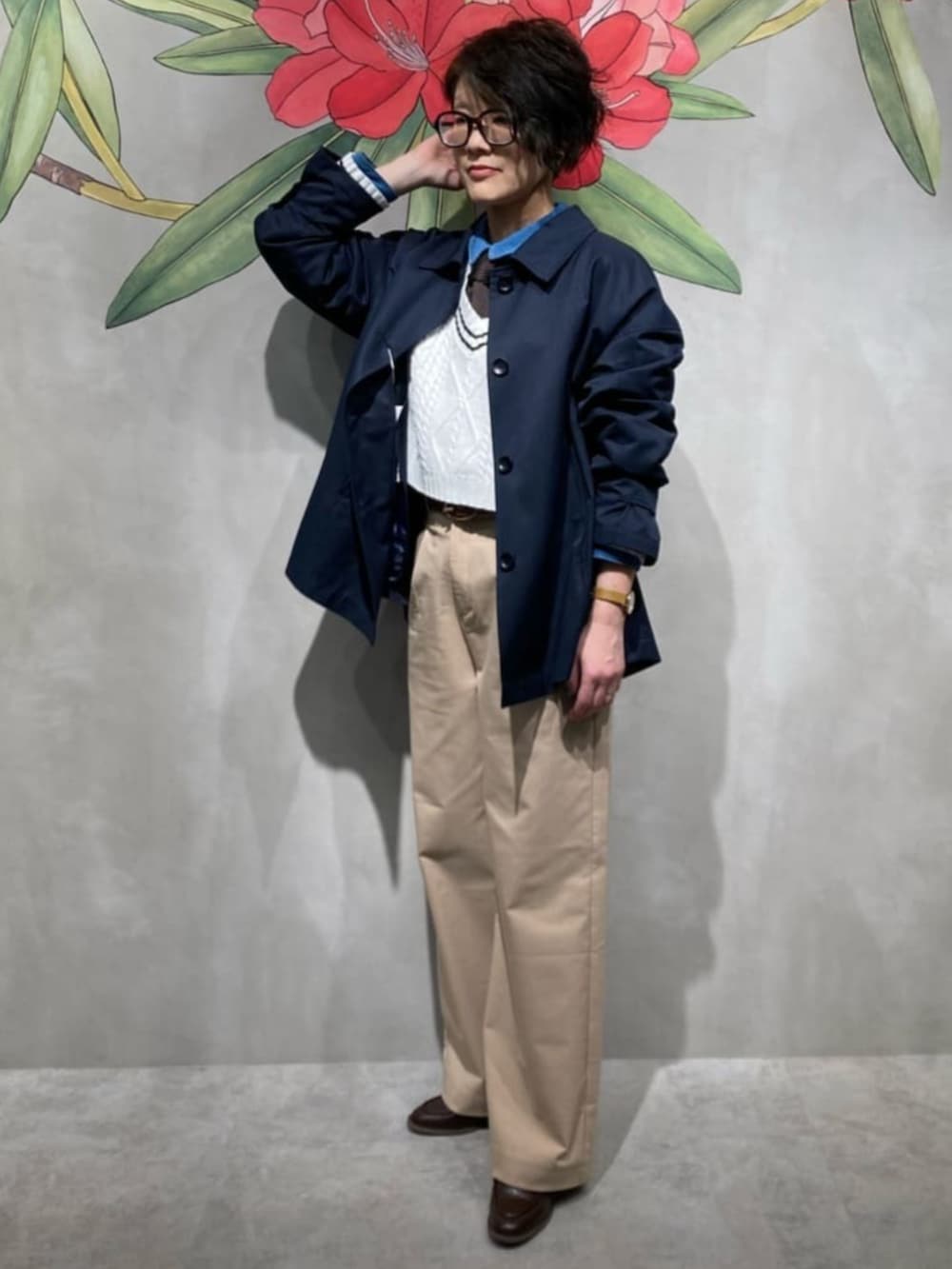 ベージュ系のチノパンツ、ブルー系のシャツ/ブラウス、ホワイト系のニット/セーターを着用したレディースの春コーディネートの3枚目の写真