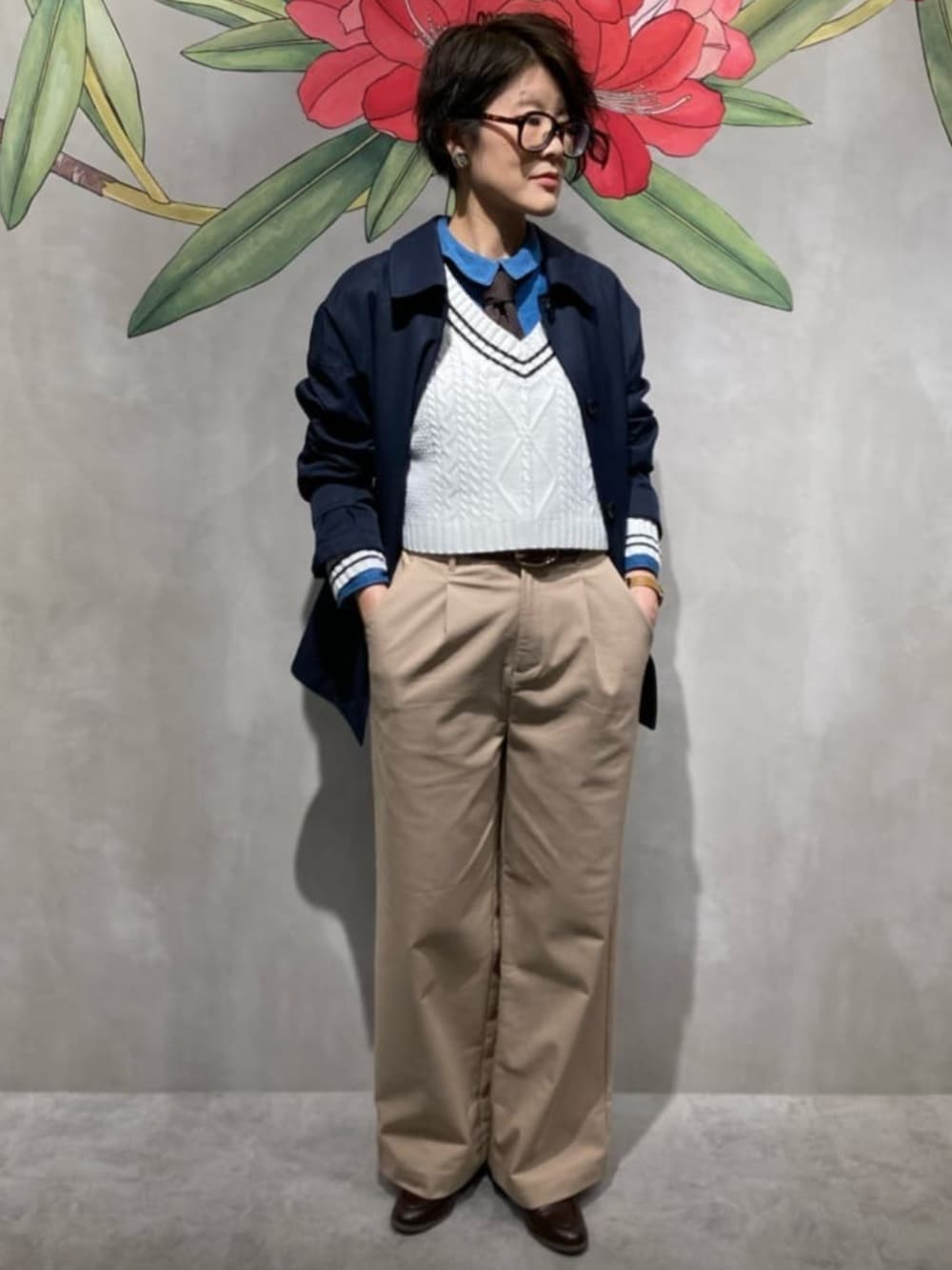 ベージュ系のチノパンツ、ブルー系のシャツ/ブラウス、ホワイト系のニット/セーターを着用したレディースの春コーディネートの2枚目の写真