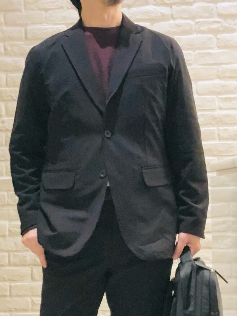 ブラック系のテーラードジャケット、ブラック系のセットアップ、ブラック系のTシャツ/カットソーを着用したメンズの秋コーディネートの2枚目の写真