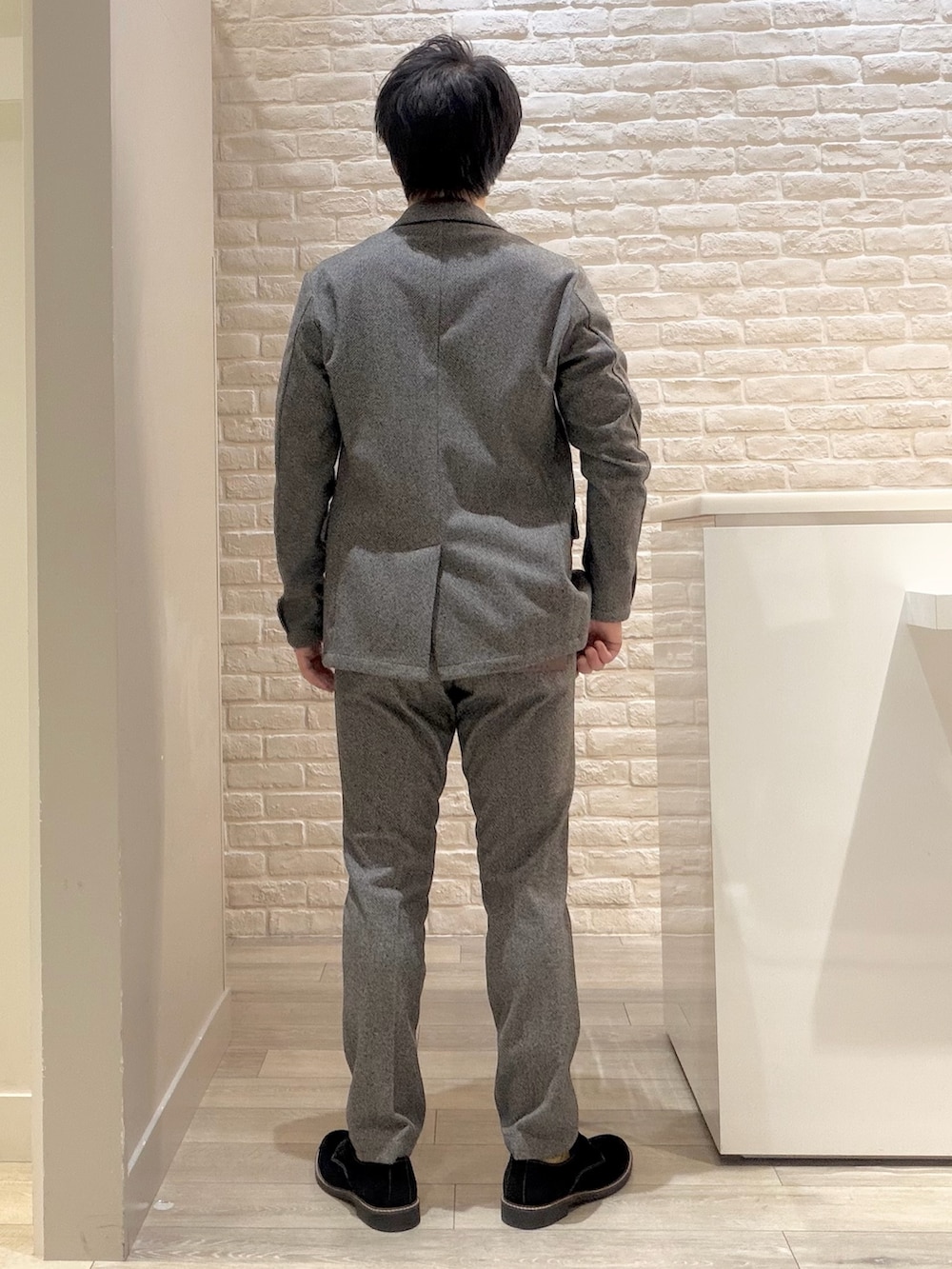 グレー系のセットアップ、ブラック系のドレスシューズ、グレー系のスラックスを着用したメンズの冬コーディネートの6枚目の写真