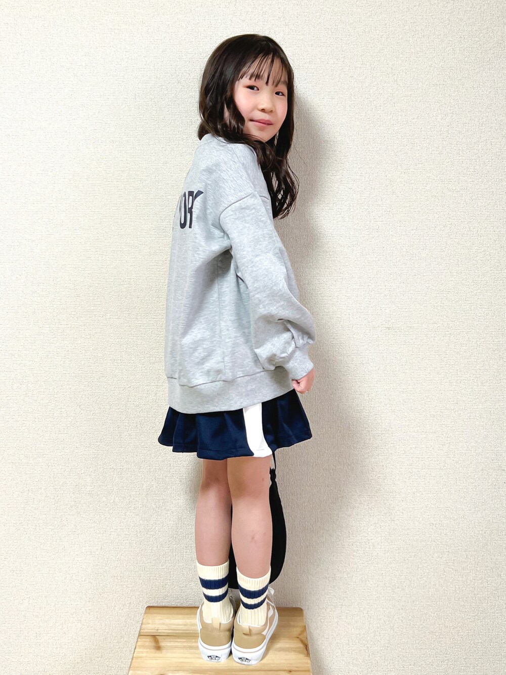 グレー系のTシャツ/カットソー、ブルー系のスカート、ベージュ系のスニーカーを着用したキッズの春コーディネートの3枚目の写真