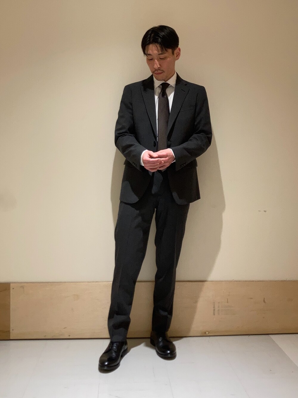 グレー系のスーツパンツ、グレー系のその他アウターを着用したメンズの冬コーディネートの2枚目の写真