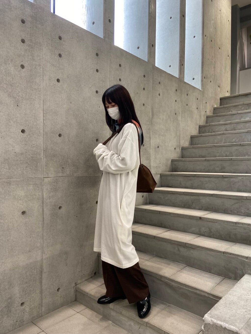 ブラウン系のその他パンツ、ブラック系のローファー、ブラウン系のショルダーバッグを着用したレディースの冬コーディネートの2枚目の写真