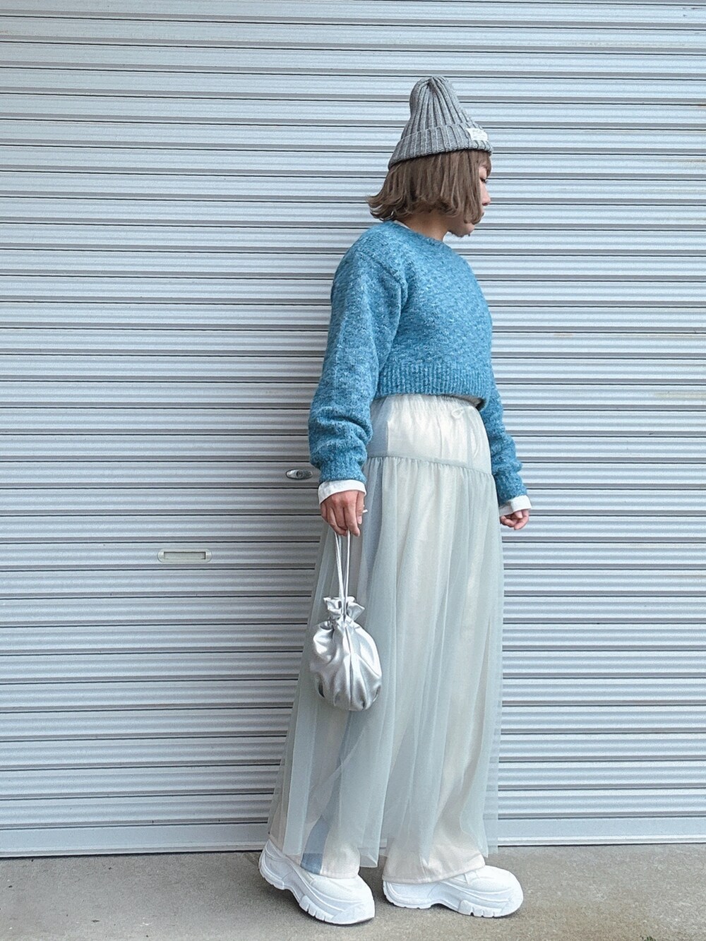 ホワイト系のその他パンツ、シルバー系のバッグ、ホワイト系のスニーカーを着用したレディースの冬コーディネートの2枚目の写真