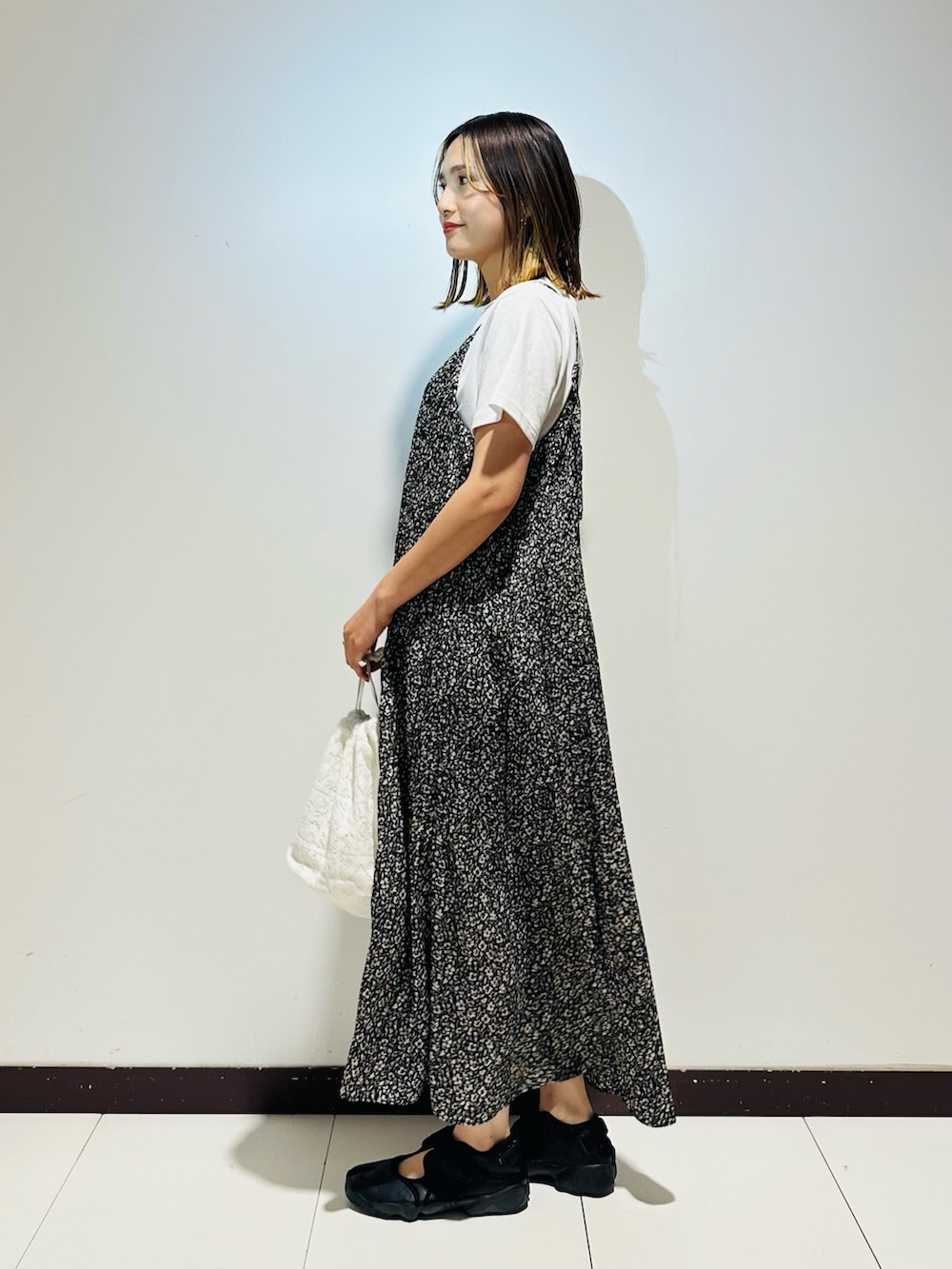 ホワイト系のショルダーバッグ、ブラック系のスニーカー、ホワイト系のTシャツ/カットソーを着用したレディースの夏コーディネートの3枚目の写真