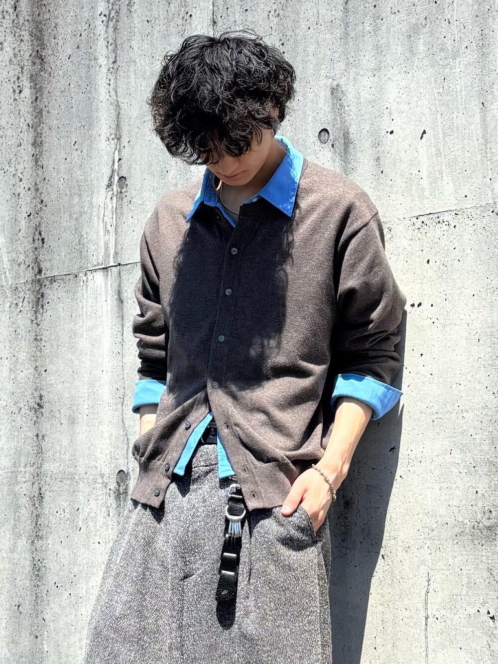 ブラウン系のカーディガン/ボレロ、グレー系のスラックス、ブラック系のドレスシューズを着用したメンズの春コーディネートの2枚目の写真