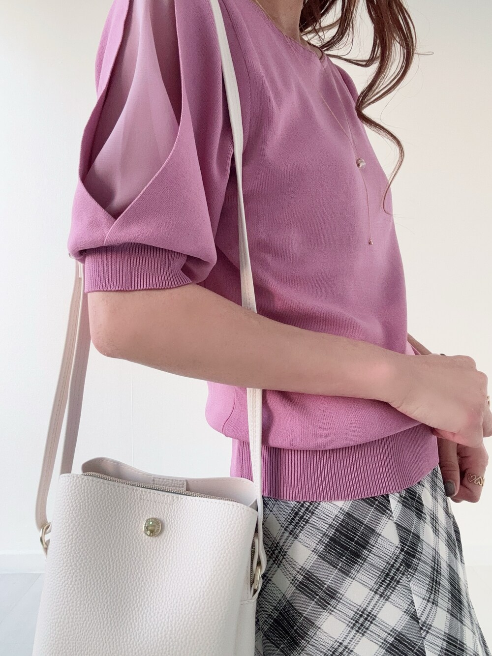 ブラック系のパンプス、ホワイト系のスカート、ホワイト系のカーディガン/ボレロを着用したレディースの春コーディネートの5枚目の写真