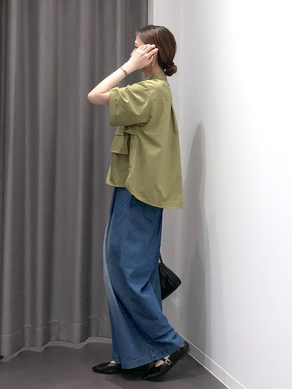 ブラック系のパンプス、ブラック系のショルダーバッグ、グリーン系のシャツ/ブラウスを着用したレディースの夏コーディネートの3枚目の写真