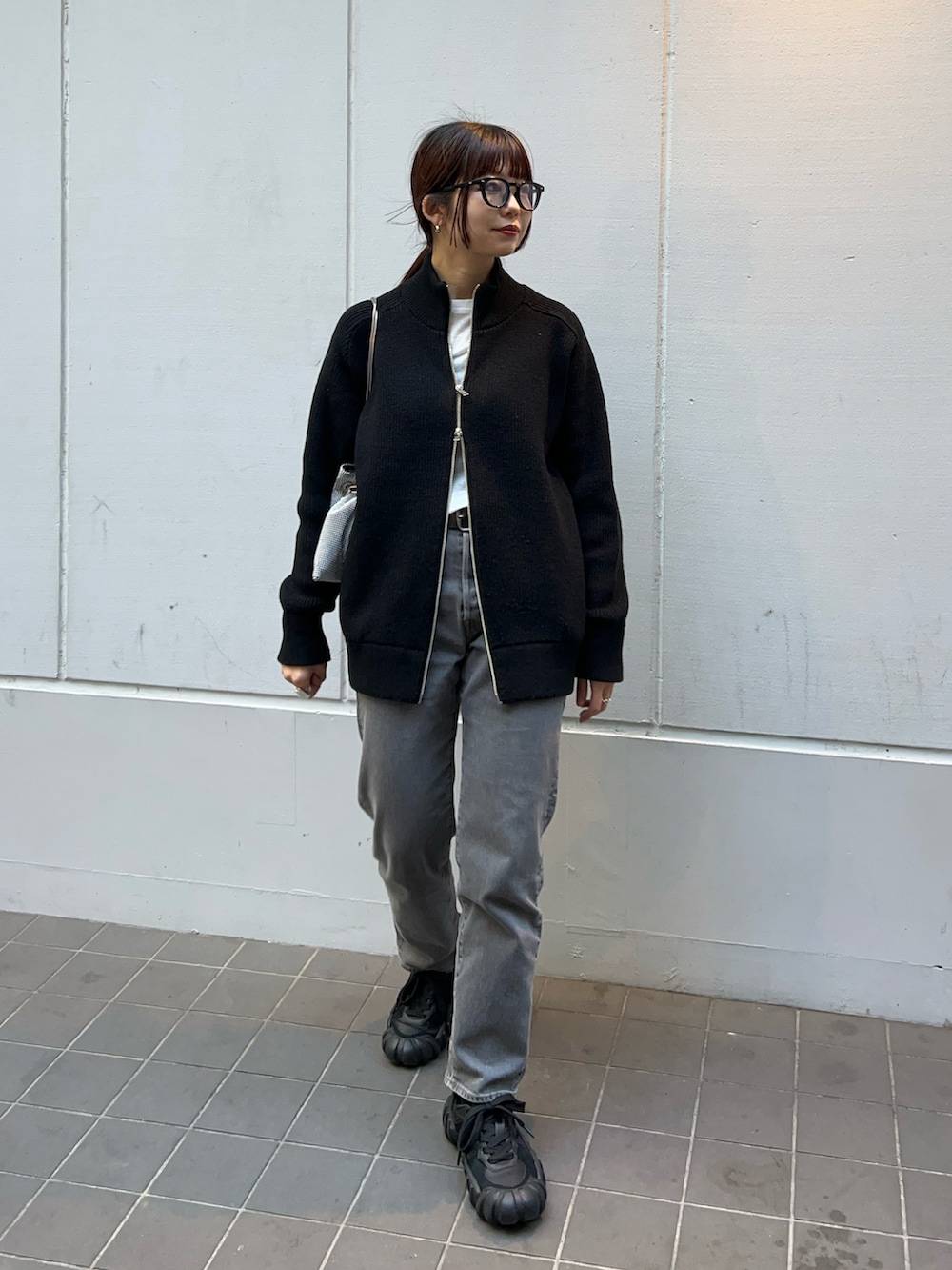 ブラック系のニット/セーター、ブラック系のその他アウター、ブラック系のデニムパンツを着用したレディースの冬コーディネートの4枚目の写真
