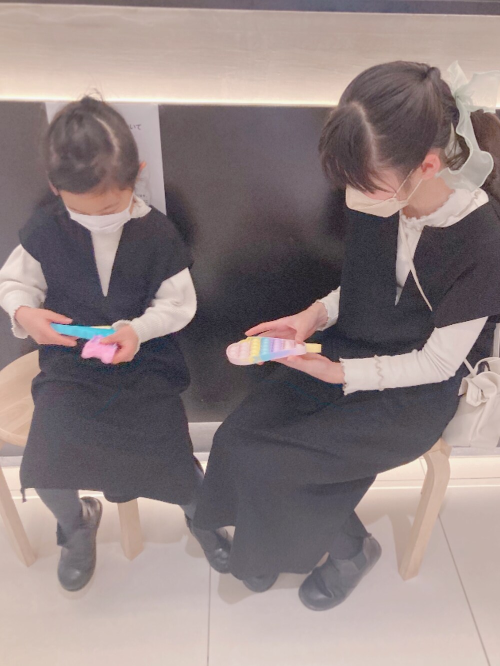 ブラック系のジャンパースカート、ブラック系のその他アウター、ブラック系のブーツを着用したキッズの冬コーディネートの2枚目の写真