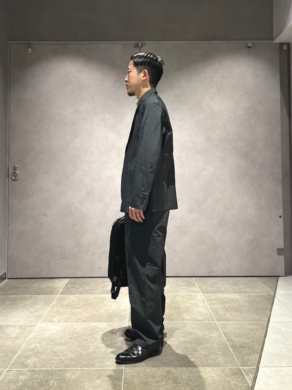 グレー系のその他パンツ、ブラック系のバックパック/リュック、グレー系のシャツ/ブラウスを着用したメンズの春コーディネートの2枚目の写真