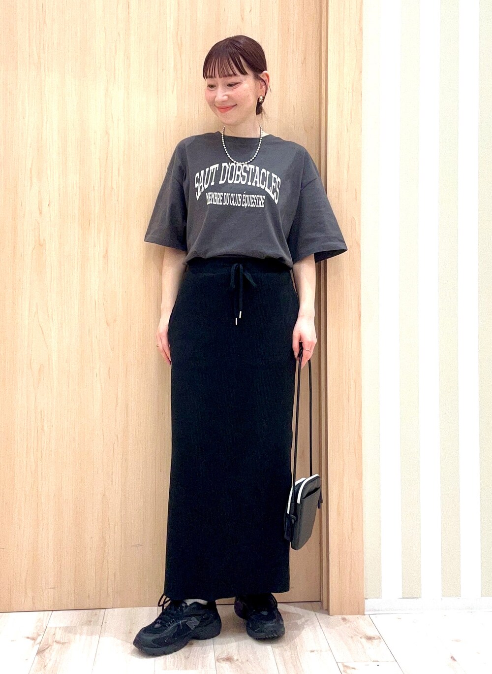 イエロー系のニット/セーター、ホワイト系のカーディガン/ボレロ、ブラック系のショルダーバッグを着用したレディースの春コーディネートの4枚目の写真