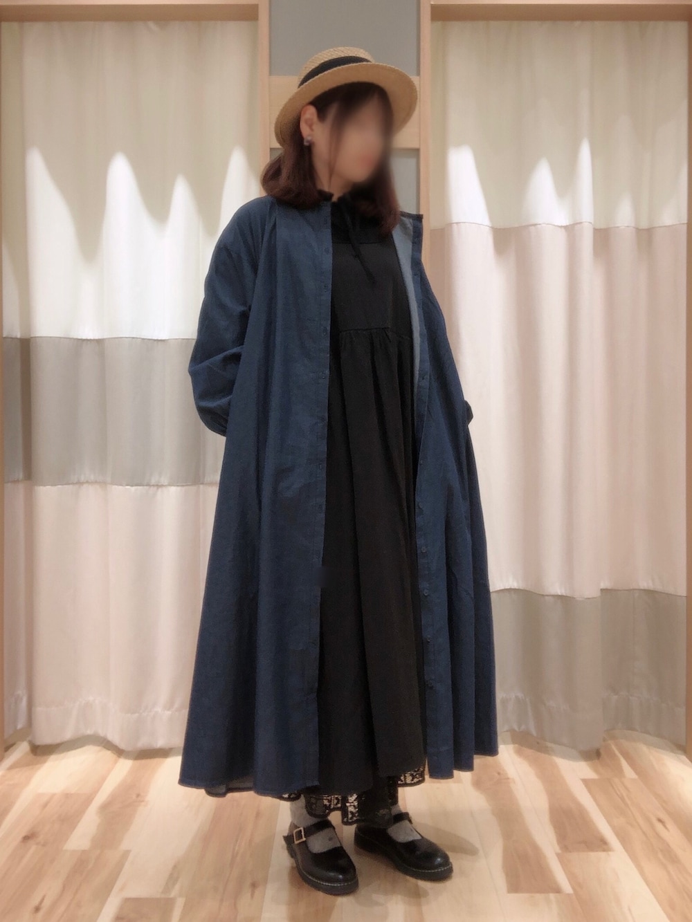 ブラック系のドレスシューズ、ホワイト系のスカート、ブルー系のワンピースを着用したレディースの春コーディネートの2枚目の写真