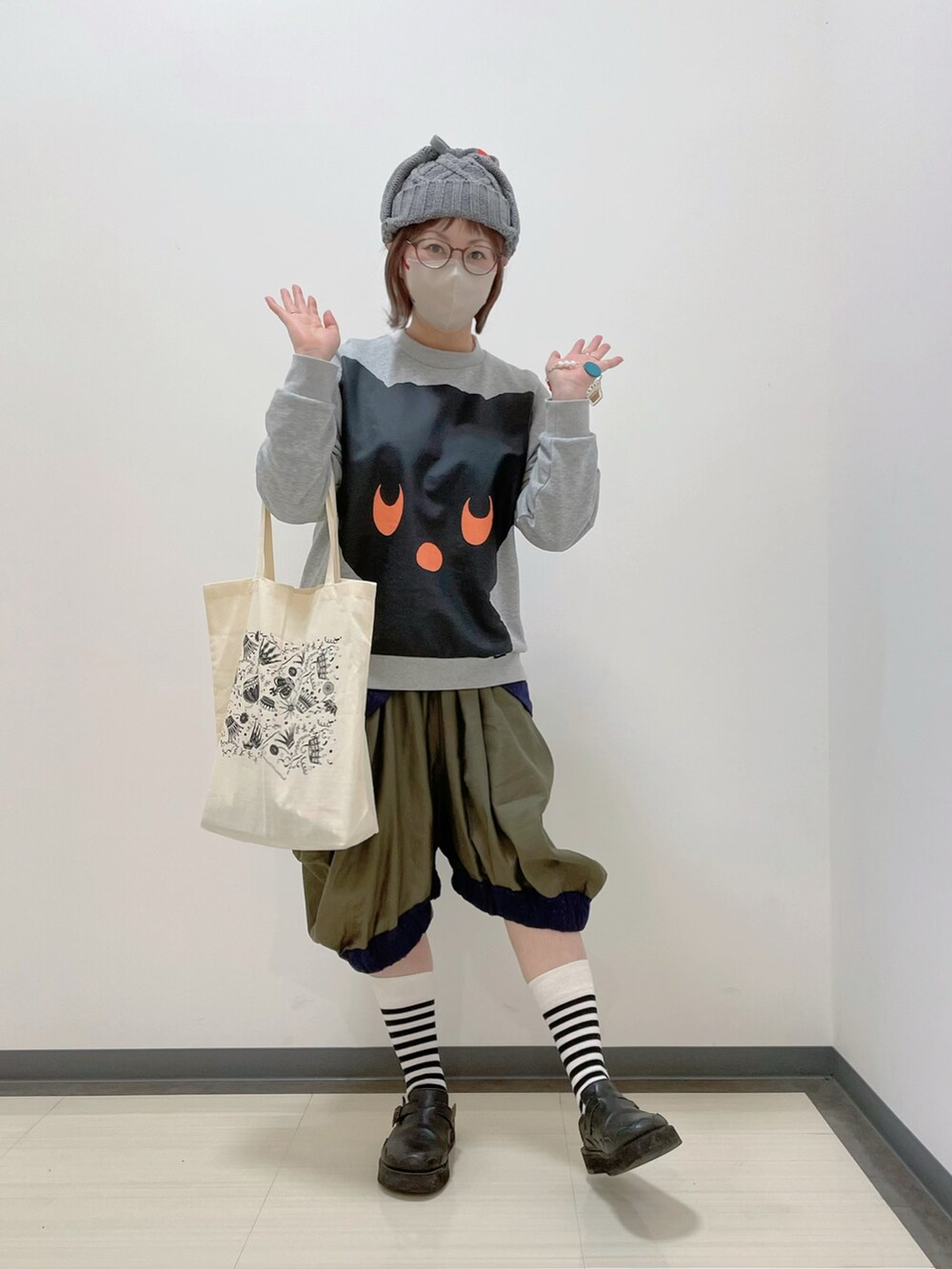 グレー系のスウェット、グリーン系のパンツ、ホワイト系のトートバッグを着用したレディースの春コーディネートの2枚目の写真
