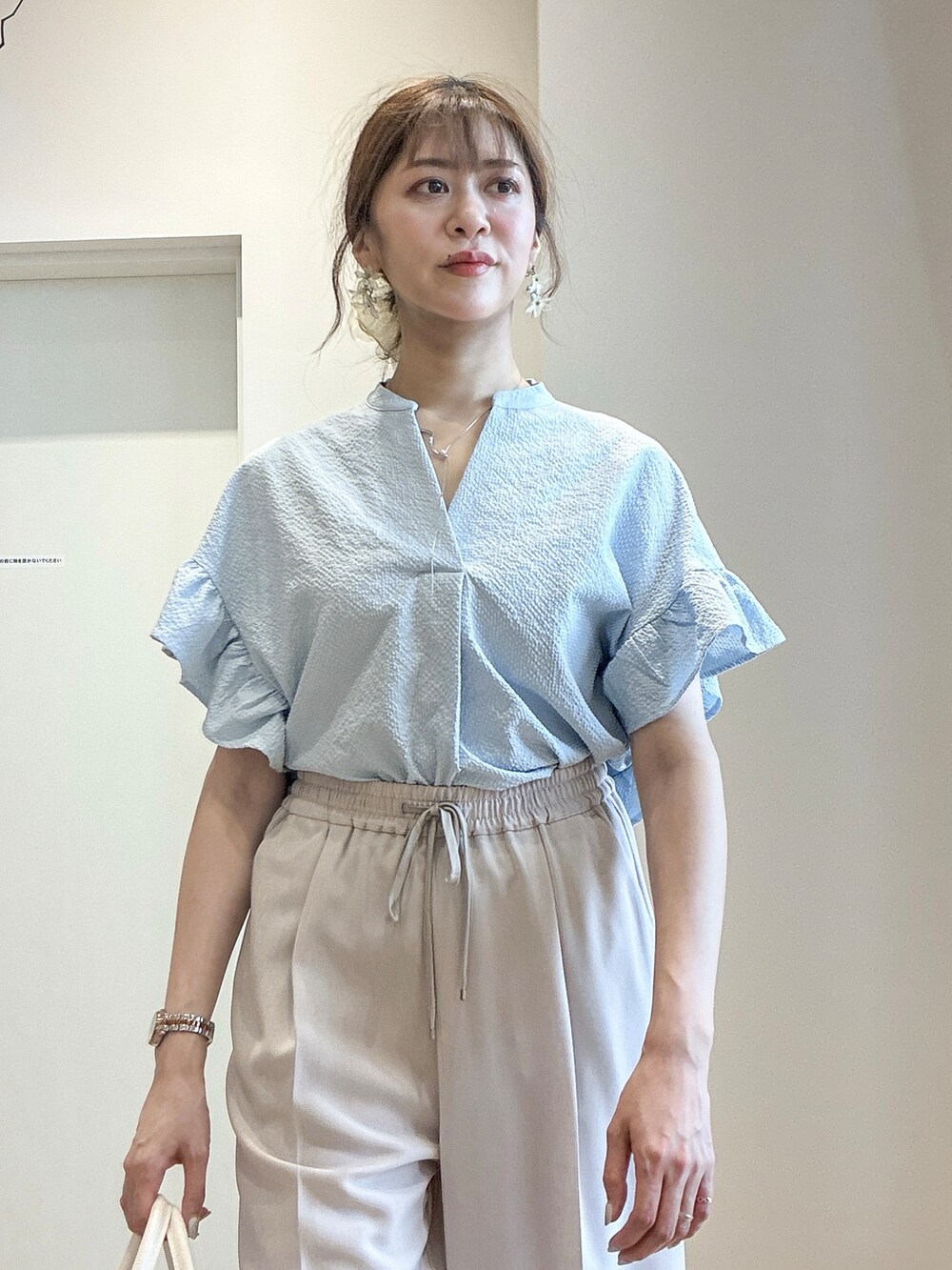 ホワイト系のショルダーバッグ、ベージュ系のその他パンツ、シルバー系のサンダルを着用したレディースの春コーディネートの7枚目の写真