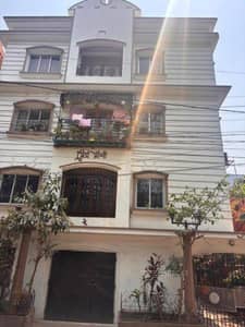 The building features balconies, plants, and windows The building features balconies, plants, and windows