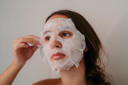 Hyaluron-Maske: BU: wie Print ++++++++++<br /> Photo of a close-up view of a young, beautiful woman applying a sheet mask during her skincare routine