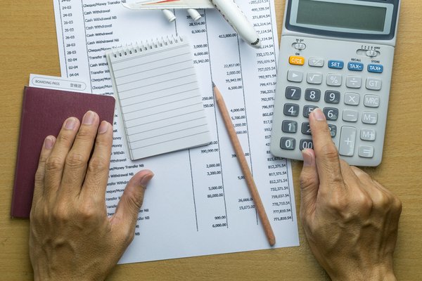 Documents and a calculator sitting on a desk.