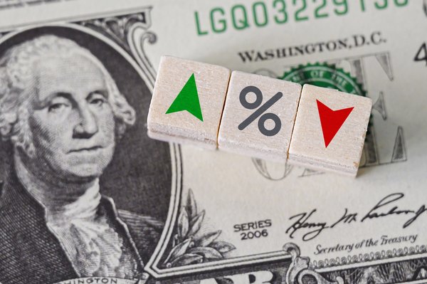 Depiction of interest rates with dollar bill and blocks with up and down arrows and percent symbol.