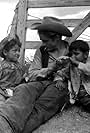 James Dean with two local children on location in Marfa, TX for George Steven's film, Giant. Summer of 1956. 