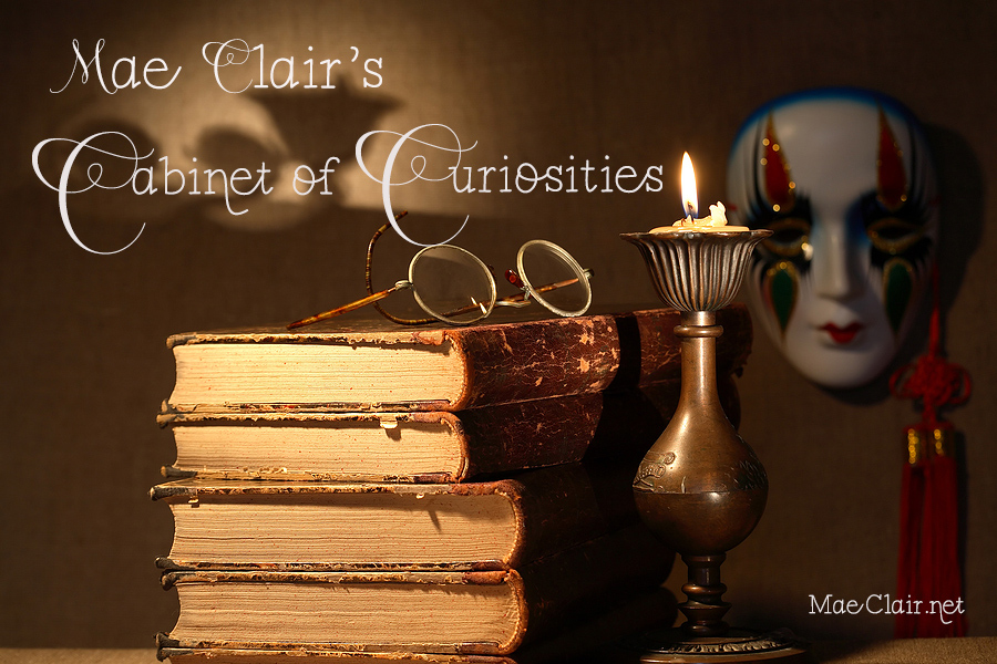 Stack of books with round eyeglasses on top, brass vintage candle, and carnivale mask in background