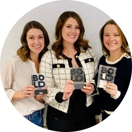 three women holding bold awards