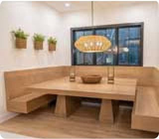 A photo of a table and booth seating under a window.