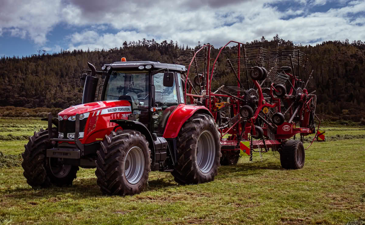 Traktor på jordet med samlerive