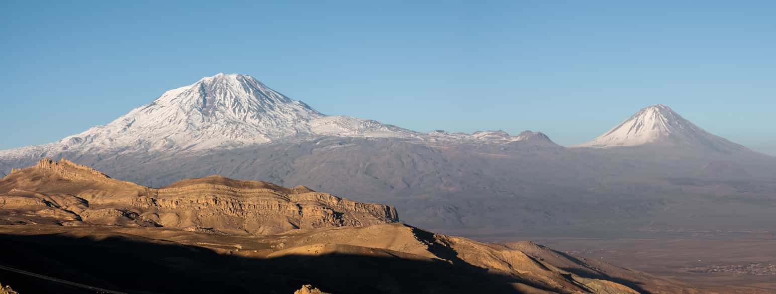 Foto av to snødekte fjelltopper