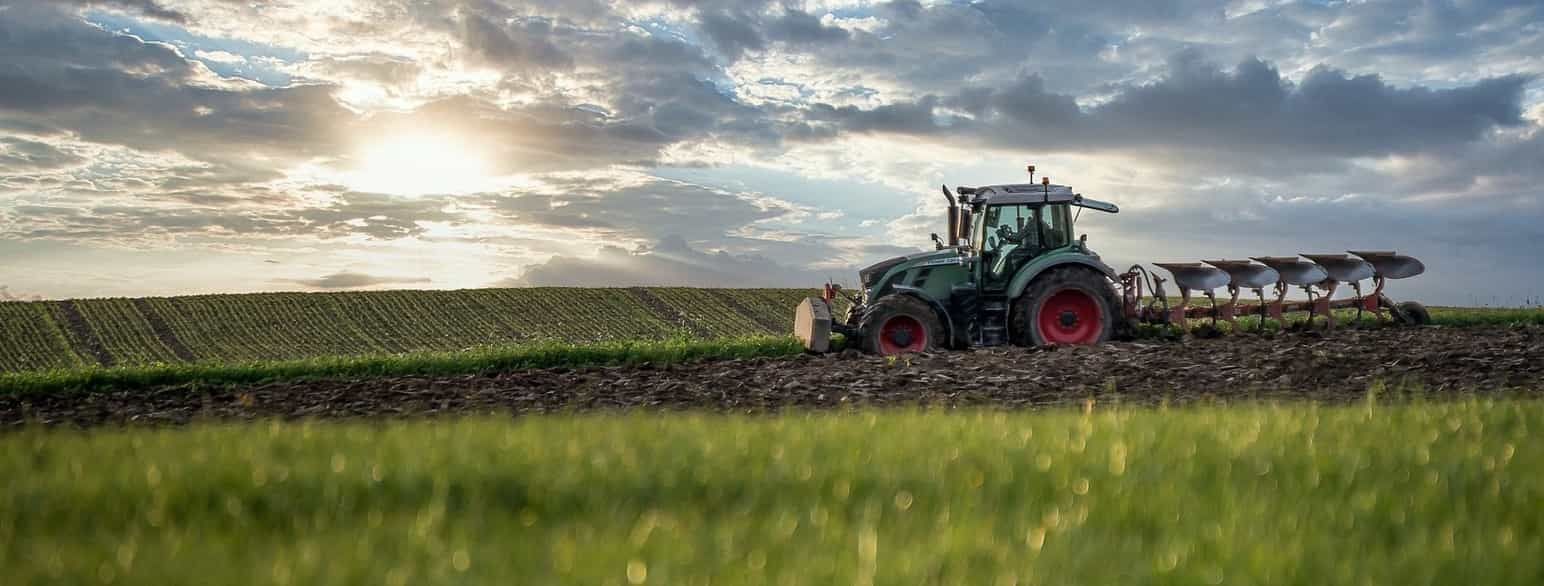 Foto av traktor i åker