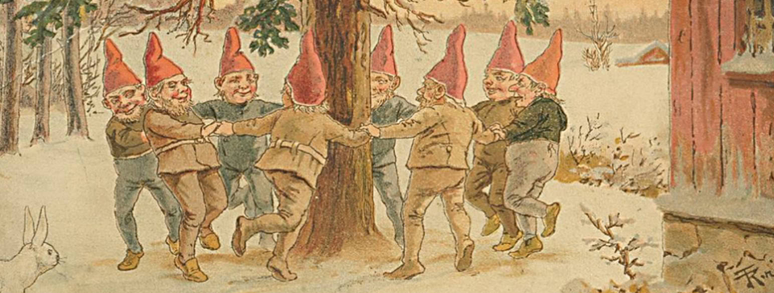 Mange nisser som danser rundt et tre. De har på seg grå klær og røde toppluer