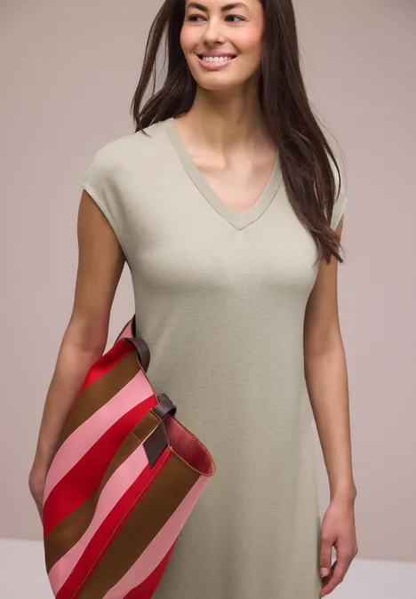 Midi-jurk met V-hals in een gebreide look timeless beige Vrouw in beige kokerjurk met V-hals en korte mouwen, met een gestreepte rode-roze-groene tas.
