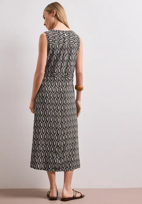 Midi-jurk met gespleten hals en ritssluiting clay sand Achteraanzicht van een vrouw in een mouwloze midi-jurk met zwart-beige geometrisch patroon en tailleband